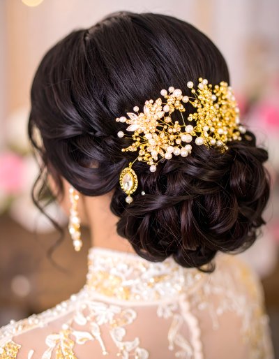 Elegant bride with updo and sparkling gold pearl hair accessory