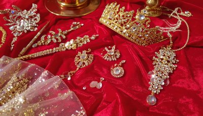 Golden crown and jewelry collection on red velvet