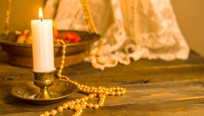 Candlelight illuminates pearls and lace, evokes nostalgic memories