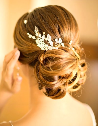 Elegant bridal updo with delicate floral hairpiece