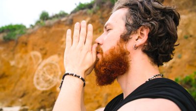 Contemplative ginger bearded man meditating in nature