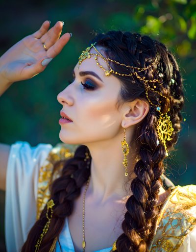 Mystical woman with gold headpiece, jewels, braids, gazing up