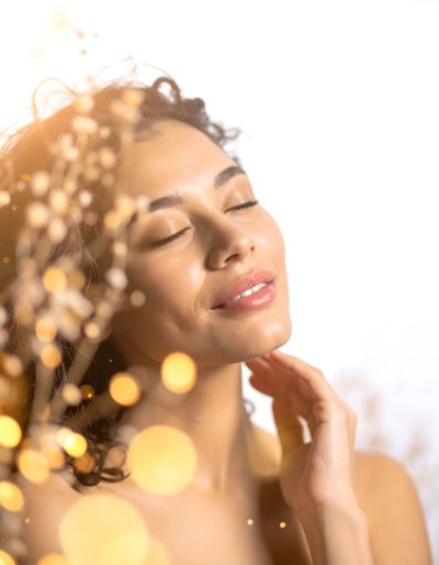 Woman's serene face with closed eyes, warm bokeh light