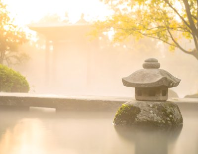 Serene Japanese garden lantern in misty morning light