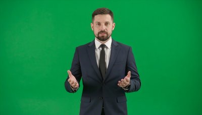 Confident business executive on green screen for video compositing