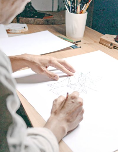 Artist sketches botanical forms with pencil in studio