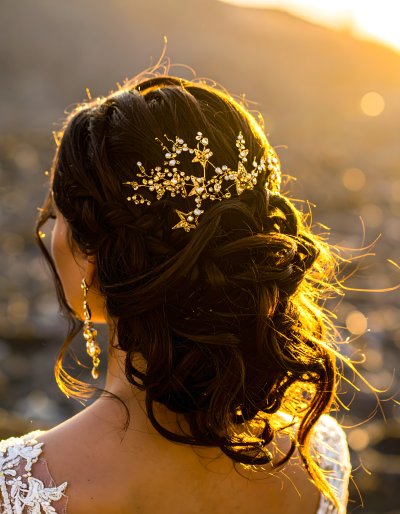 Bride's elegant updo with sparkling hairpiece in golden hour light