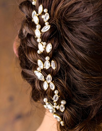 Elegant bridal hairpiece with crystals and pearls on braided hair