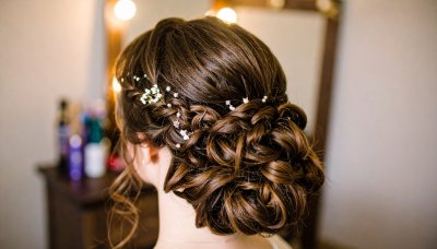 Elegant brunette updo with floral accents for a romantic wedding