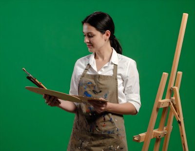 Artist with palette on clean green screen for creative compositing