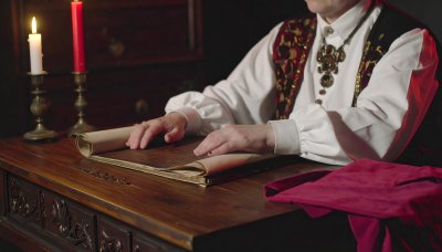 Scholar reviewing ancient manuscript by candlelight, mystery theme