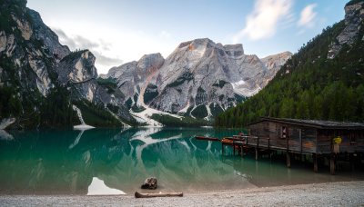 Mountain lake & boathouse; dramatic peak reflections.