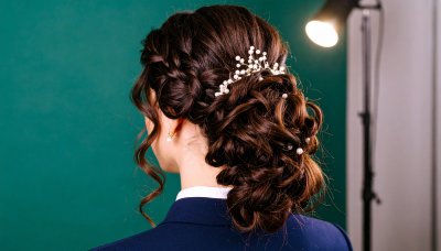 Elegant bridal updo with braids and pearls, evoking sophistication
