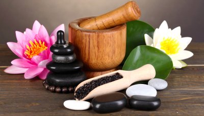 Spa arrangement with water lilies, stones, and mortar