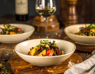 Elegant roasted dish with vegetables and meat, paired with white wine