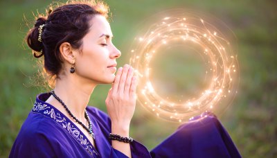 Woman meditating in nature with a warm, glowing circle of light