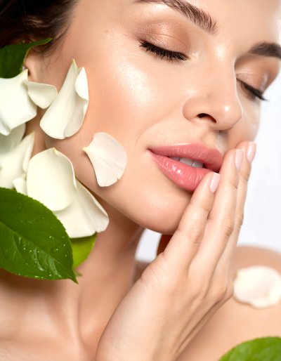 Woman's face with petals and leaves, natural beauty and freshness
