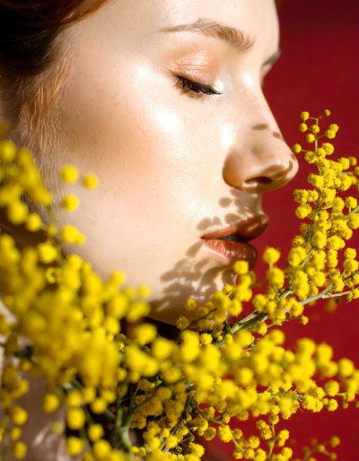 Woman's face with mimosa flowers, springtime beauty