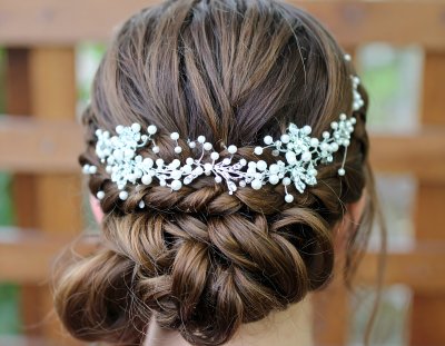Bridal updo with pearl & crystal hairpiece for romantic events.