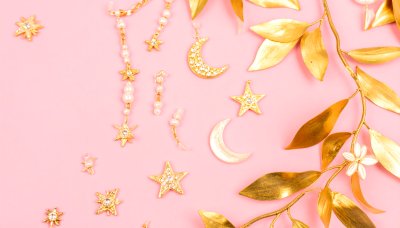 Gold celestial ornaments with pearls on pastel pink background