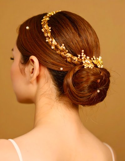 Elegant bride with a golden floral hairpiece and braided updo