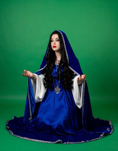 Enchanting woman in blue velvet cloak on green screen for compositing