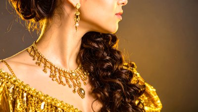 Luxurious golden jewelry set on a woman's neck and ear