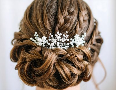 Elegant bridal updo with sparkling pearl and crystal hair accessory.