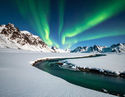Stunning Aurora Borealis over snowy landscape and river