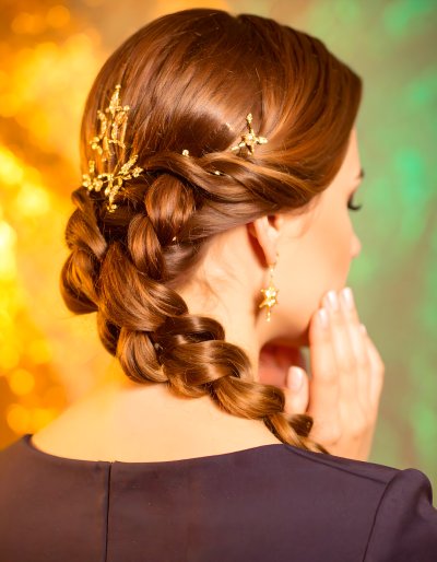 Elegant braided hairstyle with golden star hairpins and earrings.