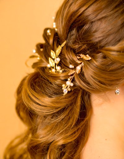 Sparkling gold leaf and pearl hair accessory in auburn hair